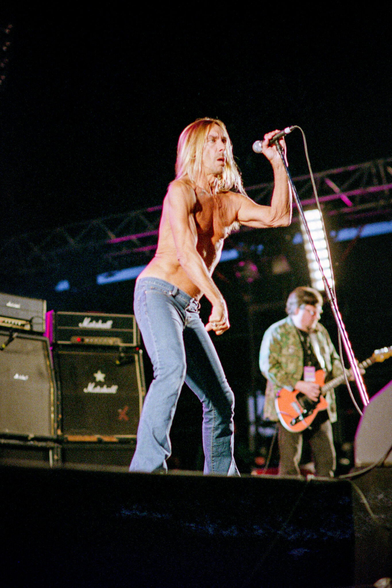 Iggy Pop s'agrippant au pied de micro lors du concert des Stooges à Chamarande.